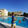 Una persona guida un gruppo in una piscina all'aperto, circondata da edifici gialli.