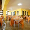 Una sala da pranzo con tavoli apparecchiati con tovaglie arancioni.