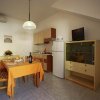 Interno di cucina con tavolo apparecchiato, frigo e credenza.