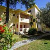 Edificio giallo con giardino esterno e alberi, percorso di pietra.