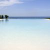 Piscina a sfioro con vista sull'oceano e cielo azzurro.