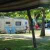Camper parcheggiato in un campeggio con sedie pieghevoli davanti.