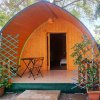 Una cabina in legno con tetto curvo, piccolo terrazzo e tavolino.