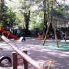 Un parco giochi all'aperto con altalena, scivoli e altre attrezzature.