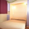 Letto matrimoniale sotto luce calda, tende viola.
