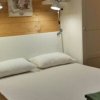 Camera con letto matrimoniale, pareti in legno chiaro.