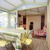 Veranda con tavolo a righe e sedie gialle.