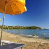 Spiaggia sabbiosa con ombrelloni gialli e mare calmo.